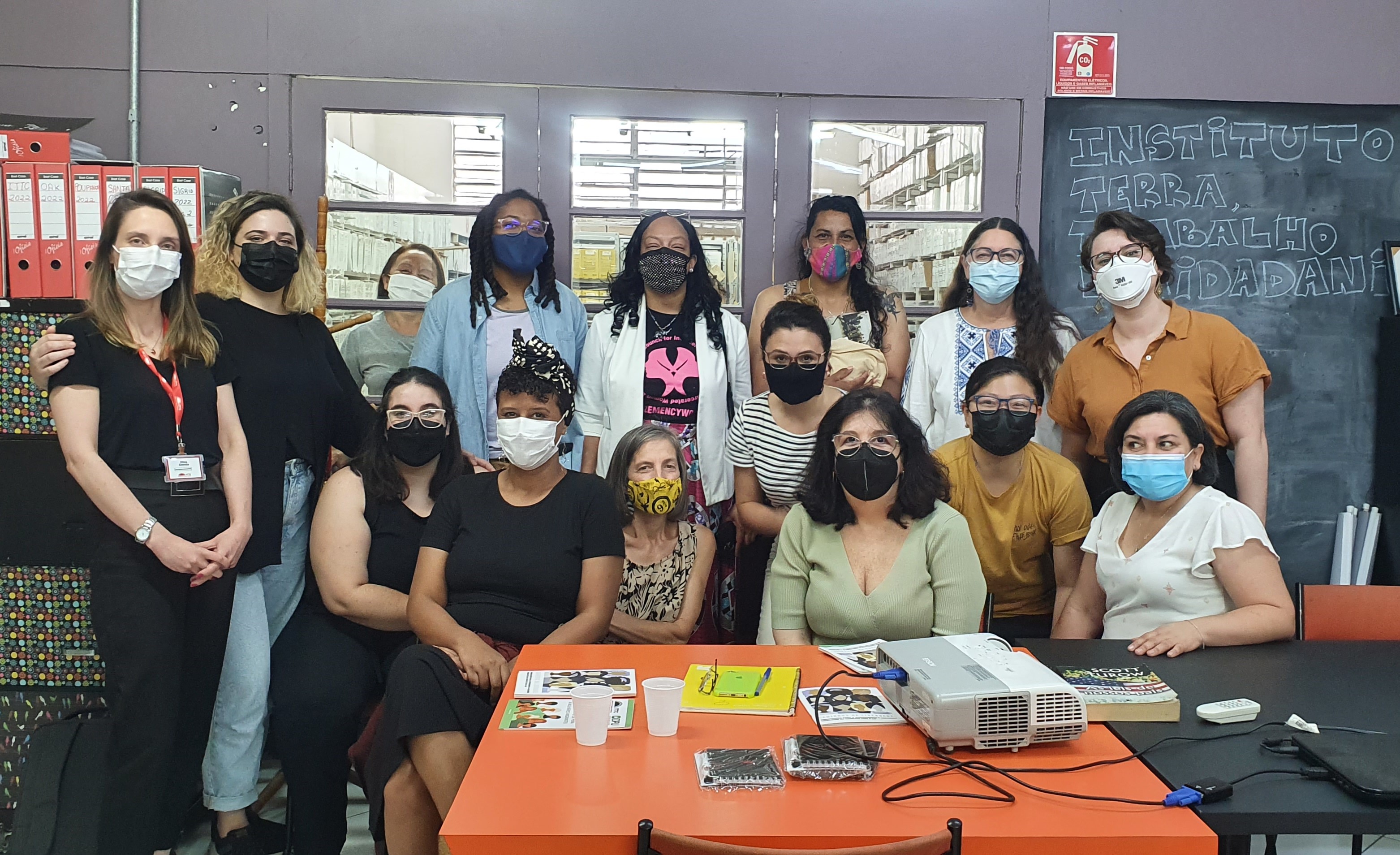 Na foto estão 16 mulheres representantes da Rede Internacional e do ITTC, 8 delas em pé e 8 sentadas na frente.. Todas estão usando máscara e utilizando roupas casuais.